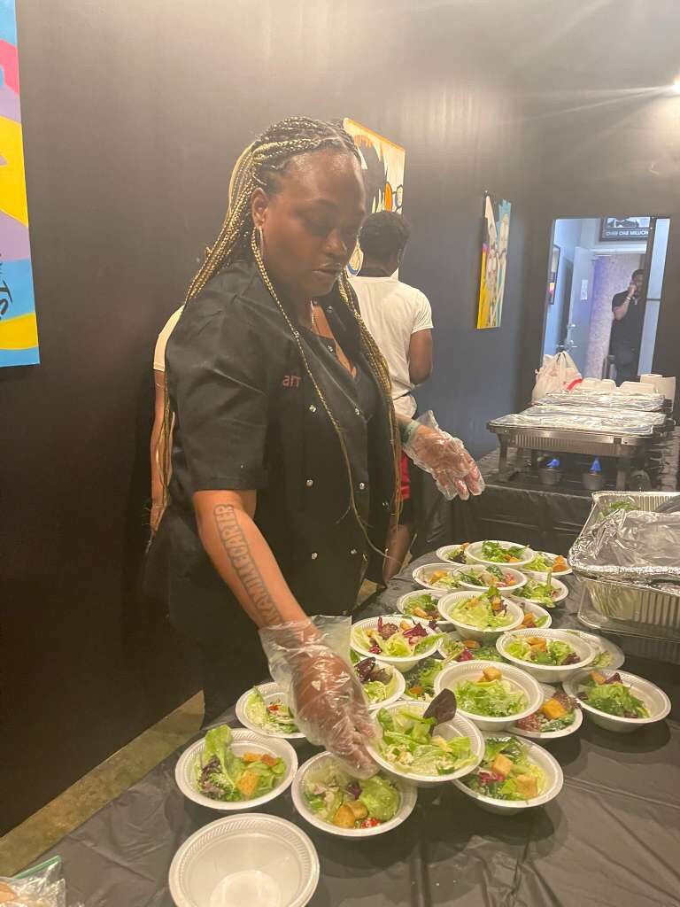 Chef Kamille plating salads at an event